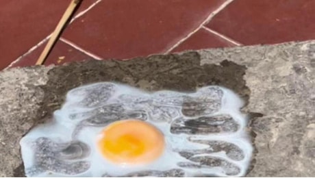 Caldo torrido a Palermo, lo chef cuoce un uovo sul muretto